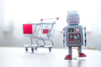 在线购物算法概念玩具机器人桌子上购物车模糊的背景