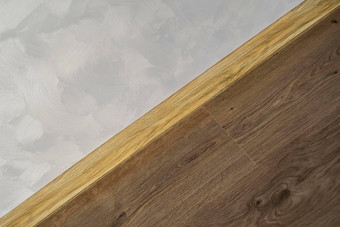 层压板塑料踢脚板木纹理新安装木层压板地板地脚线首页现代设计关闭塑料地基上黑暗木橡木地板上木条镶花之地板