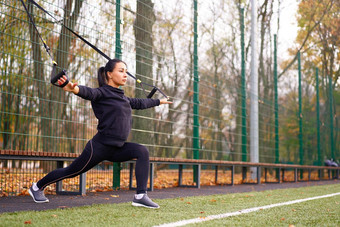 女孩运动员培训trxsportground混合<strong>比赛</strong>年轻的成人女人锻炼悬架系统健康的生活方式伸展运动在户外<strong>操场</strong>上