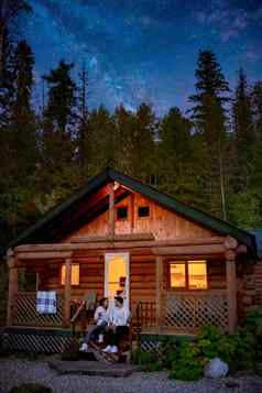 加拿大英国哥伦比亚小屋森林森林晚上夫妇喝前面木小屋远程小屋前面乳白色的