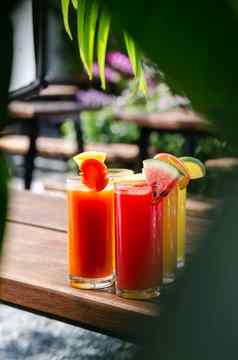 混合新鲜的有机水果果汁眼镜阳光明媚的花园表格