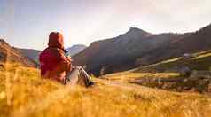 徒步旅行女孩享受日落山坐着地面温暖的颜色阿尔卑斯山脉奥地利