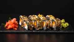 自定义寿司卷紫菜墨鱼墨水新鲜的大马哈鱼奶油奶酪胡椒南瓜鳗鱼鳗鱼酱汁可食用的黄金叶红色的姜芥末酱广场板黑色的表格背景