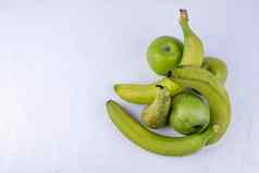 新鲜的绿色苹果梨香蕉白色木背景概念健康的食物照片