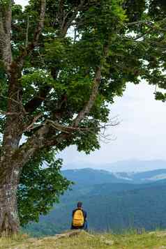 的家伙坐着悬崖享受和平绿色山景观和平心放松