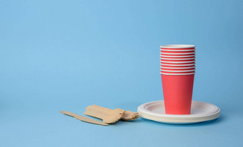 红色的纸杯白色盘子木叉刀蓝色的背景塑料拒绝概念