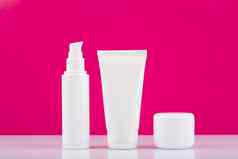 白色光滑的奶油罐子白色表格粉红色的背景概念每天皮肤护理