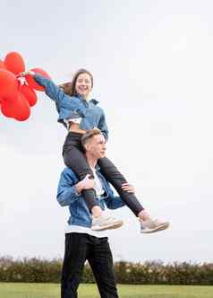 年轻的爱的夫妇红色的气球拥抱在户外有趣的
