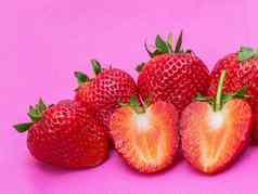 草莓甜蜜的红色的水果seed-studded表面特写镜头纹理红色的浆果心形的水果粉红色的织物