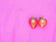 夫妇红色的心草莓甜蜜的水果特写镜头纹理红色的浆果心形的水果一半减少粉红色的织物背景