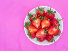 草莓甜蜜的红色的水果seed-studded表面集团红色的浆果心形的水果白色板粉红色的背景