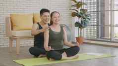 家庭夫妇女人瑜伽坐着冥想莲花构成锻炼首页男人。按摩肩膀