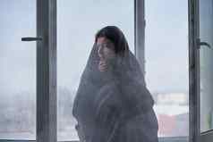 冷冬天天气女人摇晃冷坐着窗台上包装毯子冷淡的空气冲开放窗口播放住房冷冬天
