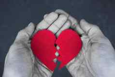 破碎的心手离婚概念单色照片红色的心布拉克白色
