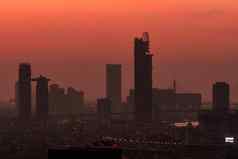 城市景观早....红色的日出天空城市覆盖烟雾空气污染问题摩天大楼建筑市中心城市天际线轮廓现代办公室酒店建筑小镇黎明