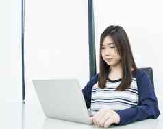 年轻的女学生坐着生活房间学习在线