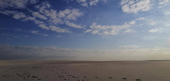 沙漠景观人工沙漠浓缩金沙冶金植物沙子地平线蓝色的天空白色云的足迹沙子