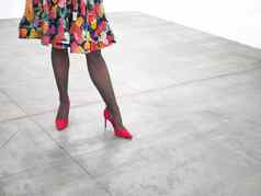 女人腿穿红色的高高跟鞋鞋子混凝土地板上关闭视图