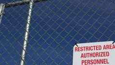 限制区域授权人员标志美国红色的信警告金属栅栏曼联州边境象征非法侵入请注意意味着违反者起诉法律
