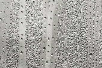 雨滴玻璃多雨的天气闪闪发光的闪亮的表面水玻璃水滴形式球球体灰色雨滴背景摘要背景点缀水