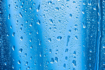 雨滴玻璃多雨的天气闪闪发光的闪亮的表面水玻璃<strong>水滴形</strong>式球球体蓝色的雨滴背景摘要背景点缀水