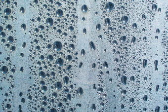 雨滴玻璃多雨的天气闪闪发光的闪亮的表面水玻璃水滴形式球球体蓝色的雨滴背景摘要背景点缀水