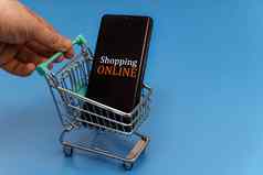 购物车智能手机蓝色的背景在线购物概念