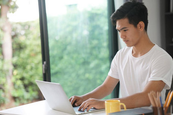 亚洲年轻的学生男人。企业家工作电脑研究学习在线首页电子学习网络研讨会会议社会距离科维德流感大流行