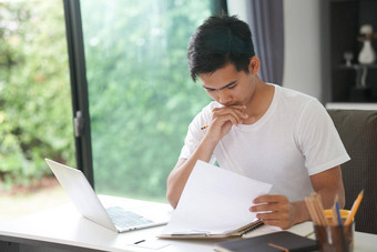 亚洲年轻的学生男人。企业家工作电脑研究学习在线首页电子学习网络研讨会会议社会距离科维德流感大流行