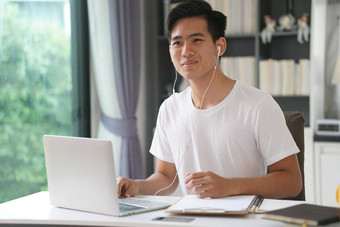 亚洲年轻的学生男人。企业家穿耳机工作视频调用会议研究学习在线首页电子学习网络研讨会会议社会距离科维德流感大流行