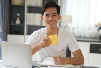 亚洲年轻的学生男人。企业家工作电脑研究学习在线首页电子学习网络研讨会会议社会距离科维德流感大流行