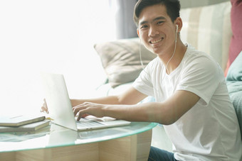 亚洲年轻的学生男人。企业家穿耳机工作电脑研究学习在线首页电子学习<strong>网络</strong>研讨会会议社会距离科维德流感大<strong>流行</strong>