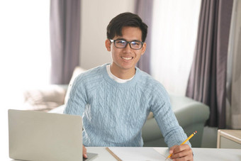 亚洲年轻的学生男人。企业家工作电脑研究学习在线首页电子学习网络研讨会会议社会距离科维德流感大流行