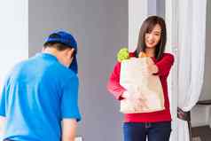 交付男人。使杂货店服务给新鲜的蔬菜纸袋女人客户