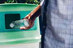 黑色的手扔空塑料水瓶回收垃圾垃圾