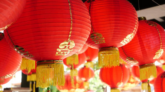 纸灯笼破旧的建筑红色的纸灯笼挂天花板饱经风霜的混凝土寺庙建筑阳光明媚的一天东方国家传统的装饰