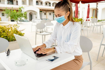 业务年轻的女人户外移动PC酒吧表格穿保护面具冠状病毒流感大流行正常的自由工作<strong>活动企业</strong>家工作移动互联网