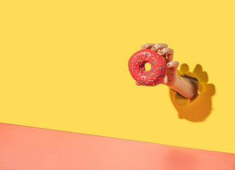 甜甜圈手撕裂黄色的背景复制空间
