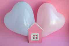气球粉红色的纸板房子粉红色的背景家庭历史符号