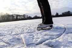 关闭女士脚穿冰滑冰靴子站冰