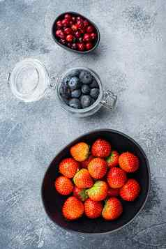 成熟的草莓蔓越莓蓝莓碗平躺变形背景