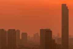 空气污染烟雾细灰尘覆盖城市早....红色的日出天空城市景观被污染的空气脏环境城市有毒灰尘不健康的空气城市不健康的生活