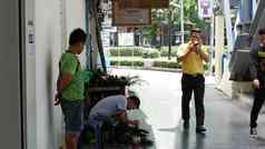 曼谷泰国7月少数民族补鞋匠工作城市街一边视图少数民族男人。坐着椅子客户端修复鞋子工作街