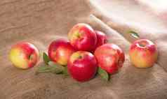 苹果谎言布粗麻布秋天水果收获织构米色背景美味的多汁的健康的水果成熟的新鲜的苹果粗糙的棕色（的）布