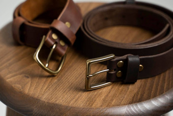 棕色（的）皮革男人的腰带青铜扣木椅子白色背景手工制作的皮革带