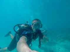 伟大的障碍礁澳大利亚10月潜水潜水男人。旅游使拇指显示细