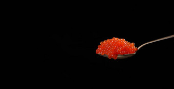 新鲜的颗粒状的红色的密友大马哈鱼鱼子酱金属勺子美味的健康的食物黑色的背景