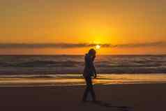 无忧无虑的女人跳舞日落海滩假期活力健康的生活概念澳大利亚