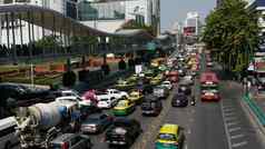 曼谷泰国12月汽车忙城市街现代汽车公共汽车骑忙街阳光明媚的一天交通交通拥堵人口过剩环境问题城市