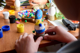 孩子的手小心翼翼地持有玩具鸡蛋复活节假期